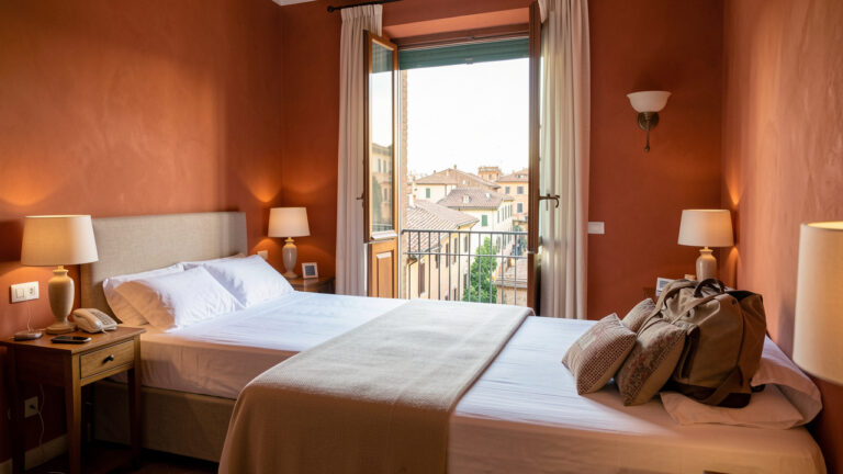 Chambre accueillante d’une maison d’hôtes à Rome avec décoration chaleureuse, équipements pratiques et vue sur les toits historiques.